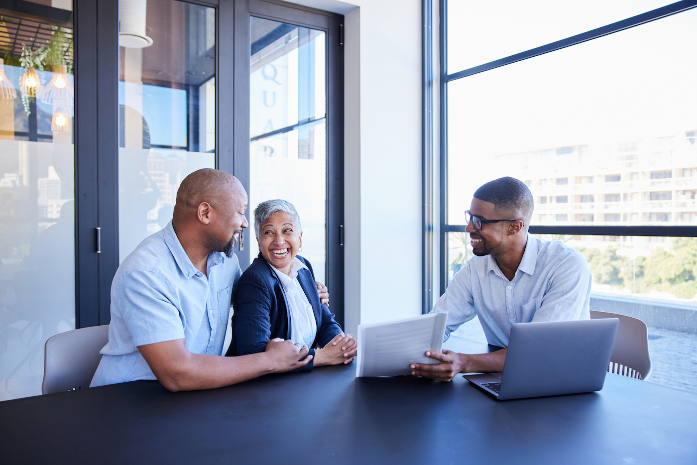 An employee couple reviewing benefits paperwork with a counselor